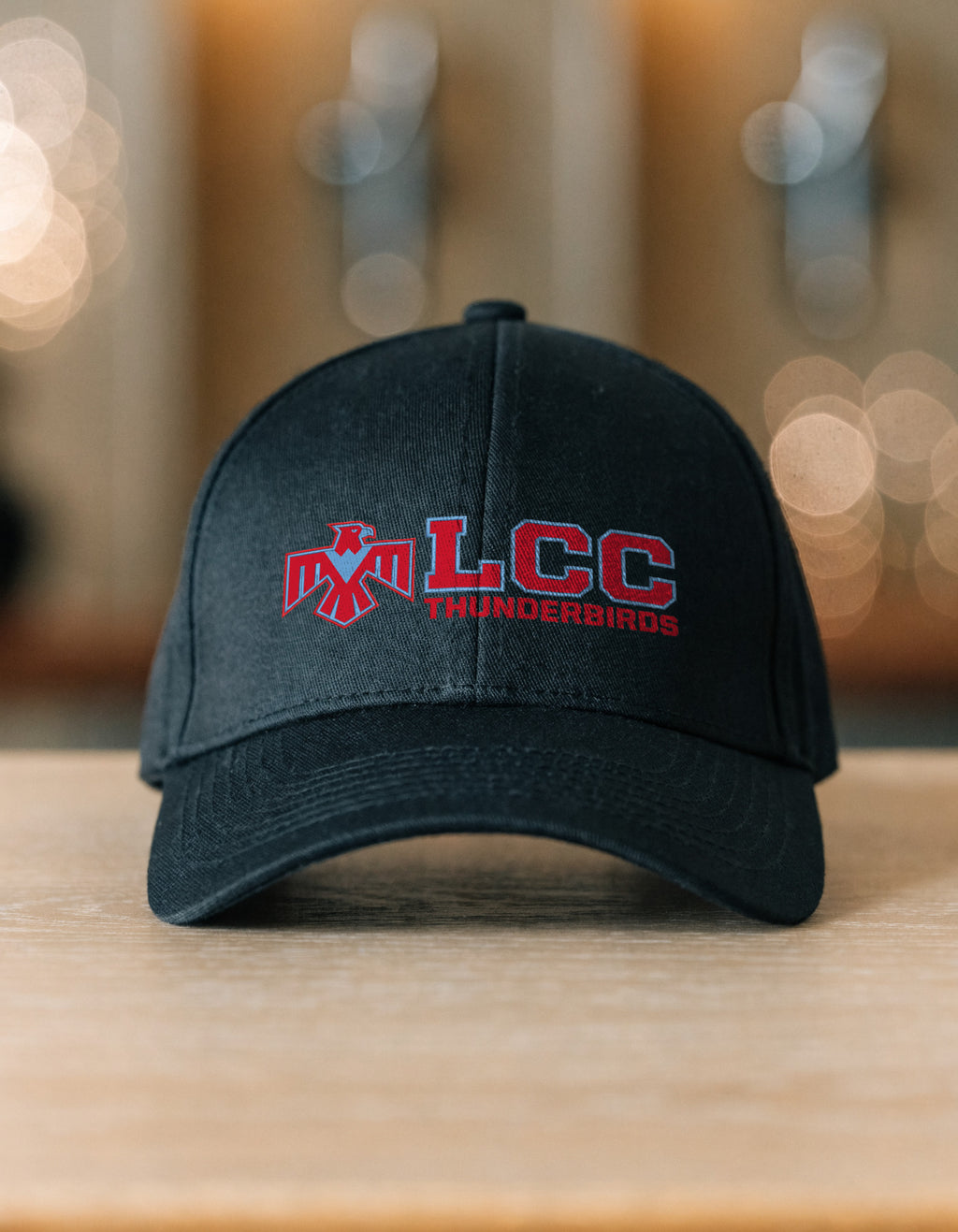 Lima Central Catholic Thunderbirds stretch fitted hat in black resting on a wood table